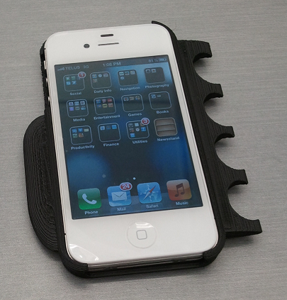 Photograph of the iPhone Adapted Case. The case has a bulge on the left side to fit the curve of the thumb and a series of rounded cut-outs on the right side for the fingers.